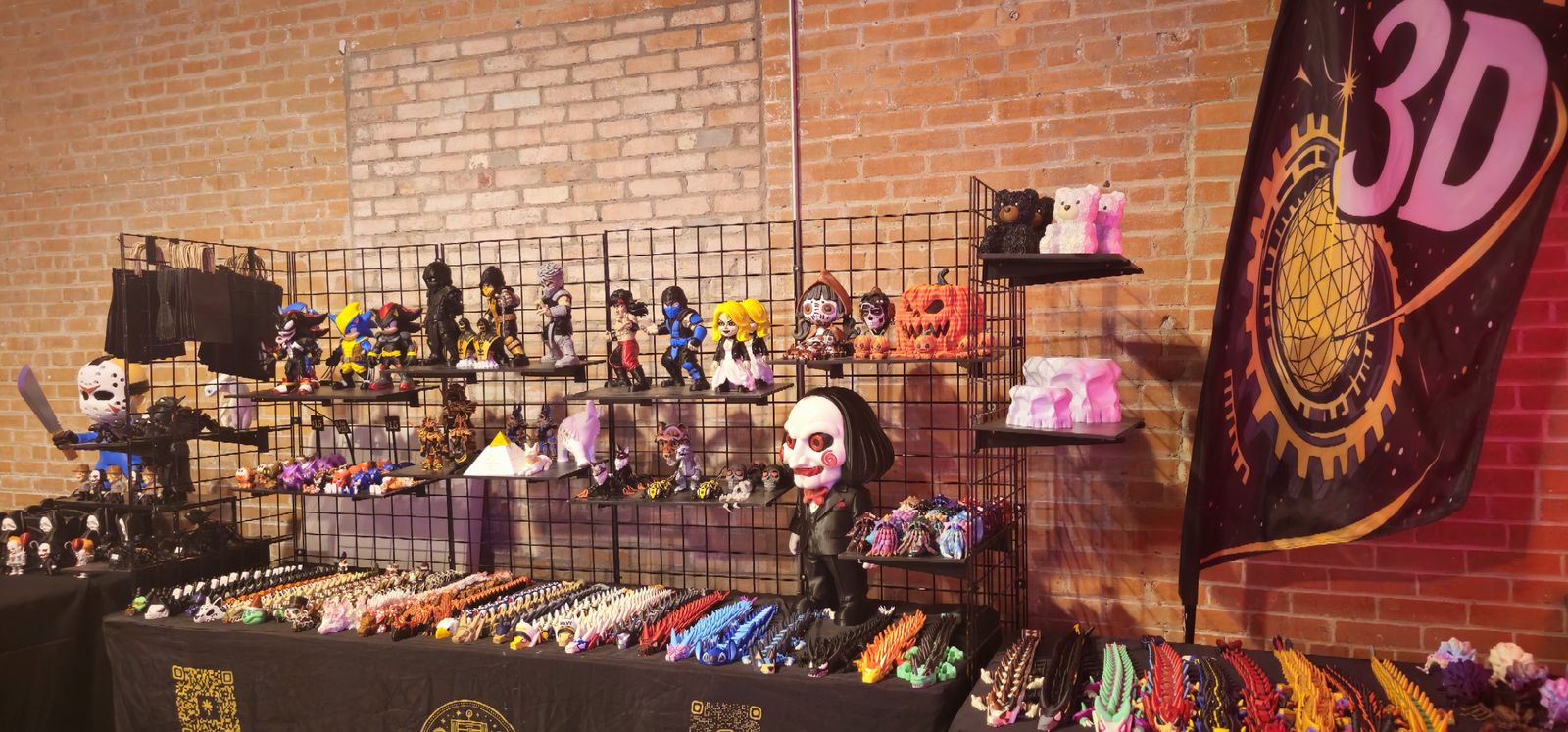 Indoor booth against a brick wall with figure shelves and a tall Kosmo Lux 3D banner