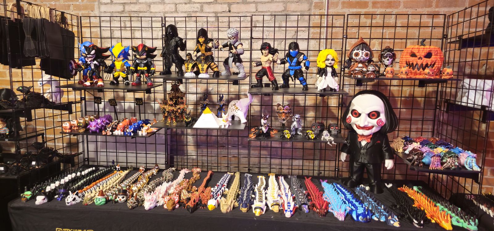 Close view of a table of colorful articulated dragons below shelves of figures