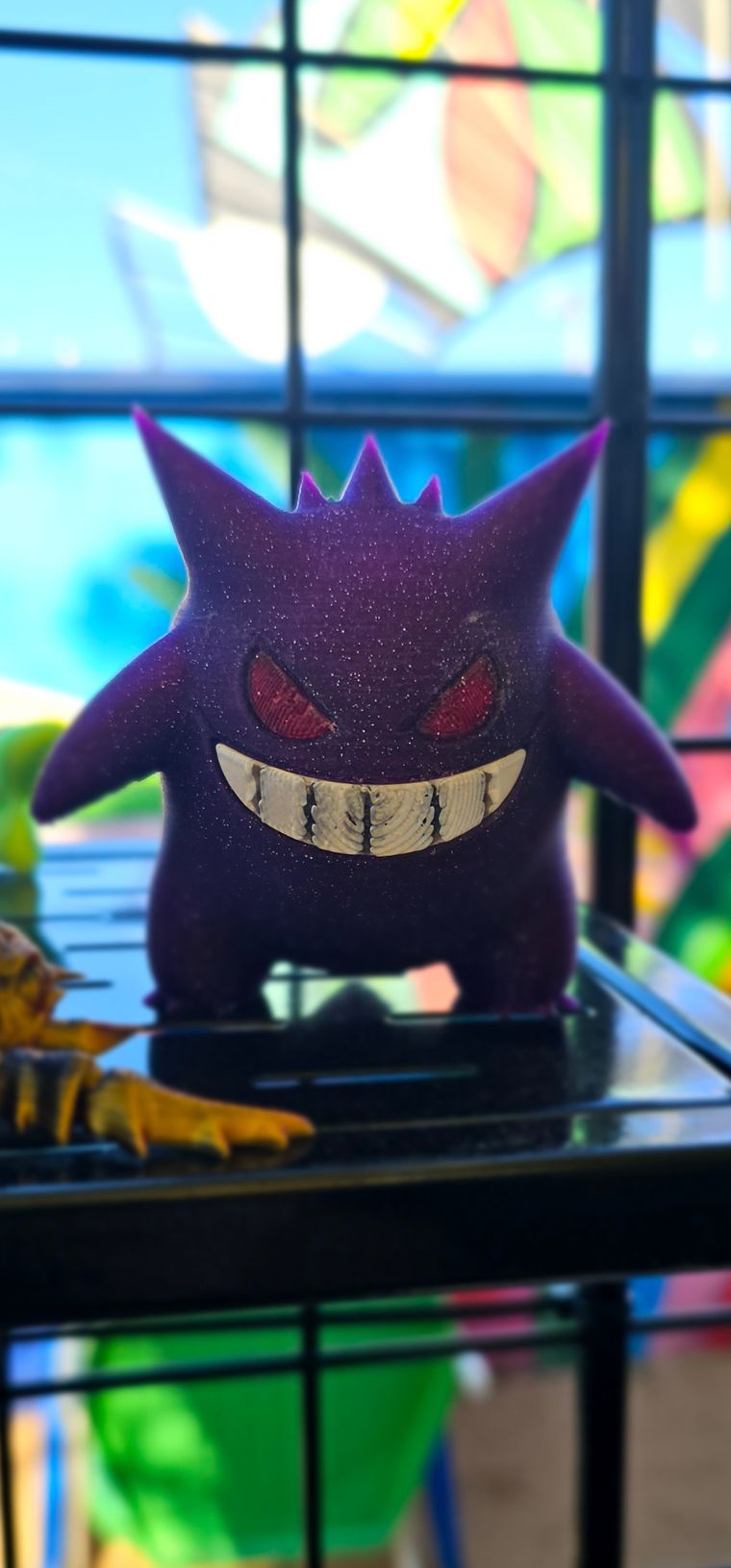 Sparkly purple Gengar figure with red eyes and a wide grin