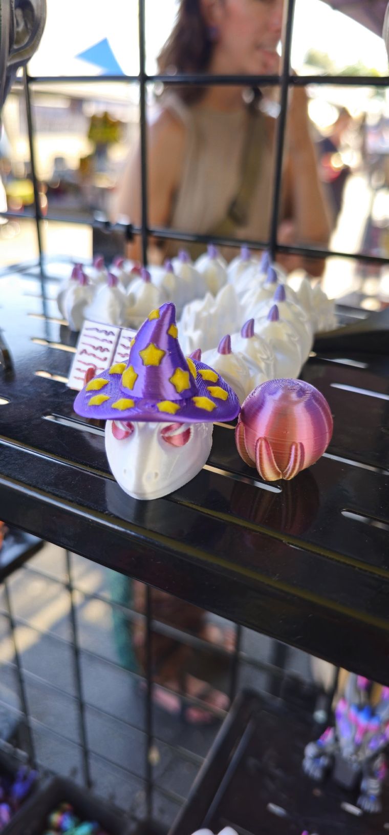 White dragon wearing a purple starry wizard hat beside a pink egg